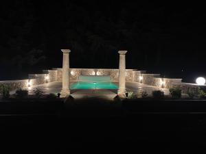 a swimming pool with lights in a building at night at Domaine La Lauren avec piscine chauffée et jacuzzi in Ferrassières