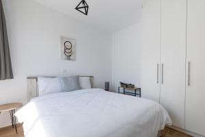 Dormitorio blanco con cama blanca y mesa en Pagani Blue - Luxury Maisonette A1, en Kalamata