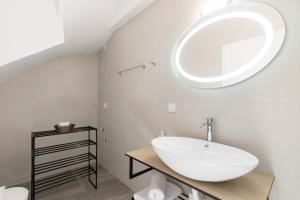 baño con lavabo y espejo en la pared en Pagani Blue - Luxury Maisonette A1, en Kalamata