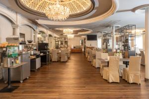 a restaurant with tables and chairs and a chandelier at Adhhoc Hotel in Naters