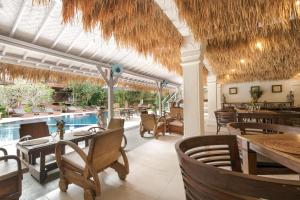 a restaurant with tables and chairs and a swimming pool at Artini 2 Cottage Ubud in Ubud