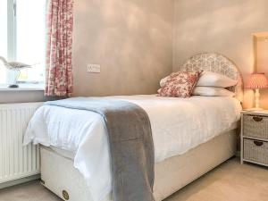 a bedroom with a bed and a window at Cherry Cottage in Gargrave