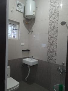 a bathroom with a sink and a toilet at Karpagam Residency in Ooty