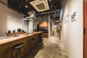 a bar in a kitchen with two stools at HELIO HOSTEL SAPPORO in Sapporo