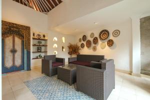 a living room with couches and plates on the wall at Artini 2 Cottage Ubud in Ubud