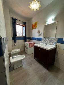 a bathroom with two sinks and a toilet and a mirror at Casa di Maria in Diamante