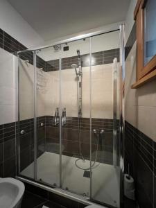 La salle de bains est pourvue d'une douche en verre et de toilettes. dans l'établissement Mary's house, à Rome