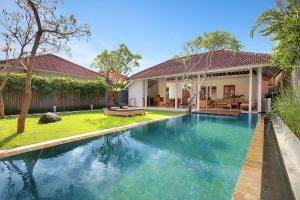 an image of a swimming pool in front of a house at Uma Sapna Seminyak in Seminyak