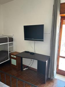 a desk with a flat screen tv on a wall at Casa di Maria in Diamante