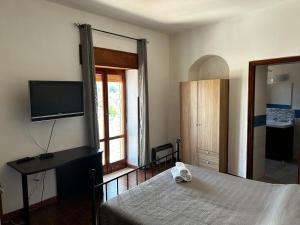 a bedroom with a bed and a flat screen tv at Casa di Maria in Diamante