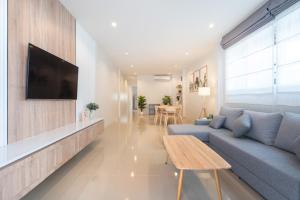 a living room with a couch and a tv on a wall at 2BR Homey townhome 350M walk to Kata Beach Fully equipped in Kata Beach +27 photos