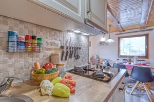 a kitchen with a counter with vegetables on it at Rozi's Riverside Cottage - Happy Rentals in Osilnica