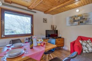 a dining room with a table and a television at Rozi's Riverside Cottage - Happy Rentals in Osilnica