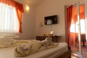 1 Schlafzimmer mit 2 Betten und einem TV an der Wand in der Unterkunft Villa Chiara in Krnica