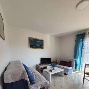ein Wohnzimmer mit einem Sofa und einem Tisch in der Unterkunft Apartman Krivokapic in Igalo