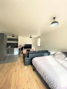 ein Schlafzimmer mit einem Bett und einem Sofa sowie eine Küche in der Unterkunft La maison Baz in Deauville
