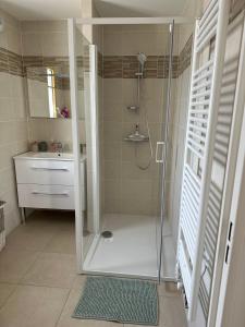 y baño con ducha y puerta de cristal. en La maison Baz en Deauville