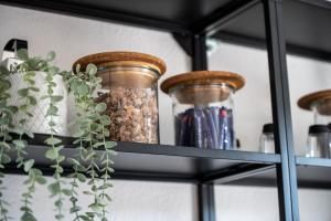 un estante con jarras de semillas y una maceta en Modernes Apartment am Campus - Parken - Smart-TV - Kaffeevollautomat, en Wernigerode