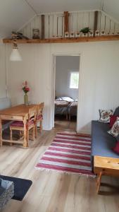 a living room with a table and a room with a bed at Rosa's stuga in Tasebo