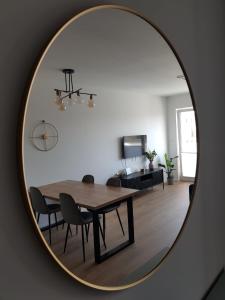 a dining room with a table and chairs in a mirror at Apartament Wyłom 8 in Poznań