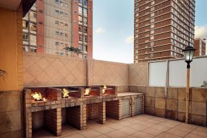 a balcony with a fire pit on a building with tall buildings at The Oceanic 1 bedroom with Ocean views - Self-catering Apartment in Durban