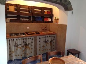 a kitchen with a counter and a table with chairs at Pantelleria 4 passi dal mare in Pantelleria