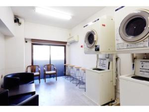 Zimmer mit einer Küche mit Stühlen und einer Mikrowelle in der Unterkunft Hotel Business Villa Omori - Vacation STAY 08185v in Tokio