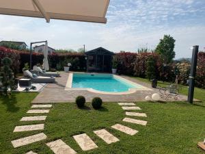 een achtertuin met een zwembad in een tuin bij Rossodisera in Sarzana