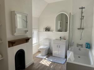 a white bathroom with a sink toilet and a mirror at Arundel Maltravers in Arundel
