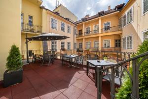 an outdoor patio with tables and an umbrella at Old Town - Aparthotel Michalska in Prague