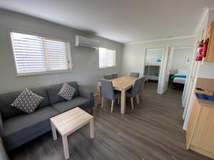 a living room with a couch and a table at Christies Beach Tourist Park in Christies Beach