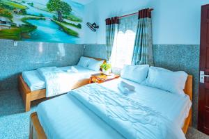 een slaapkamer met 2 bedden en een bank bij Khách Sạn Ngọc Hoa in Thăng Bình