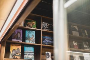 HELIO HOSTEL SAPPORO في سابورو: رف كتاب ممتلئ بالكتب في النافذة
