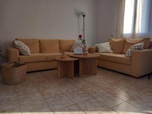 a living room with a couch and two tables at Korali in Symi