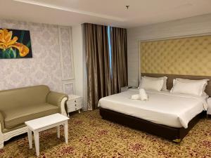 a hotel room with a bed and a couch at De Palma Hotel Shah Alam in Shah Alam
