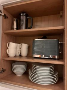 a toaster oven on a shelf in a kitchen at Little Corners in Shawford