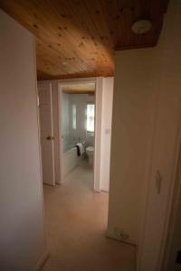 een hal van een badkamer met een toilet en een plafond bij The Little House in Uplyme
