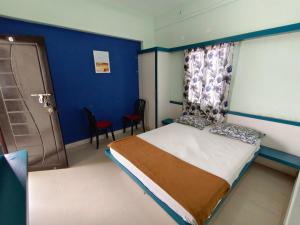 a bedroom with a bed with a blue wall at Sree Theja Residency in Anantapur