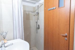 a bathroom with a shower and a wooden door at Mahane Yehuda Market Apartment Jerusalem in Jerusalem