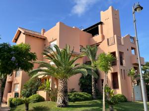 a building with palm trees in front of it at Spirit of Mar Menor in Torre-Pacheco