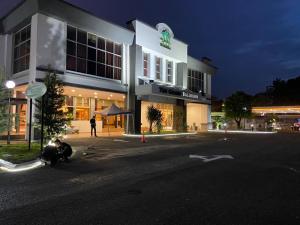um edifício com uma pessoa sentada do lado de fora à noite em De Palma Hotel Shah Alam em Shah Alam