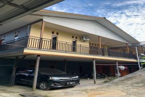 a car parked in front of a house at SPOT ON 92544 Senja Homestay in Balikpapan