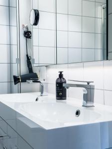 - un lavabo dans la salle de bains avec une bouteille de savon dans l'établissement Holmestrand, leilighet på bryggekanten, à Holmestrand