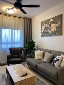 uma sala de estar com um sofá e uma ventoinha de tecto em Shanin's Homestay em Kuala Terengganu
