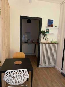 a living room with a table and chairs and a radiator at La douce chambrée de Guingamp in Guingamp