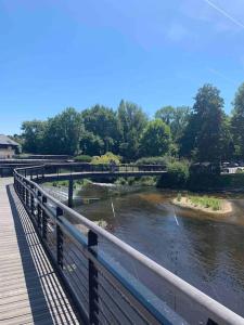 un puente sobre un río junto a un río con un puente en La douce chambrée de Guingamp en Guingamp