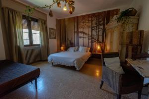 a bedroom with a bed and a table and a chair at Art b&b Gli Aironi in Pomposa