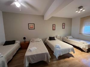 パラス・デ・レイにあるペンシオン プラザのベッド3台とソファが備わる部屋