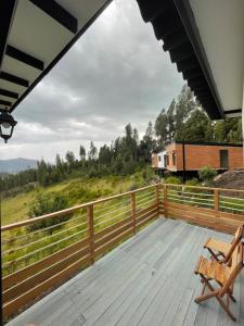 una terraza con un banco y un tren en la distancia en Cabaña Rural con excelente vista, en Duitama