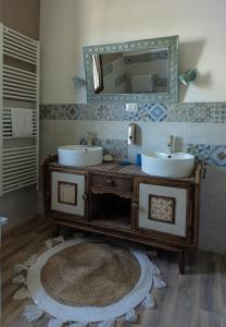 a bathroom with two sinks and a mirror at Art b&b Gli Aironi in Pomposa